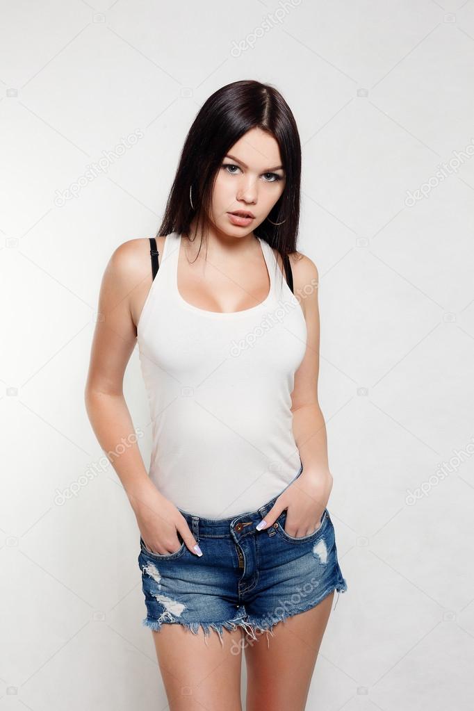 Brunette girl in a white t-shirt and denim shorts — Stock Photo