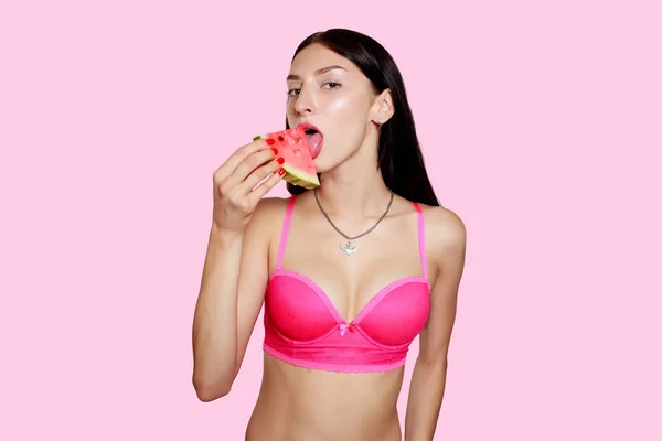 Menina com fatia de melancia em um fundo rosa — Fotografia de Stock