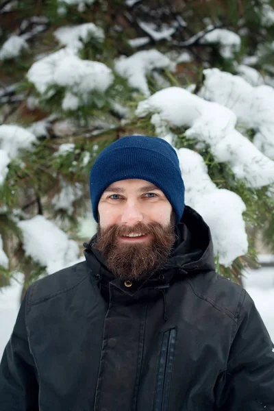 Бородатый мужчина в зимней шляпе улыбается портрет крайности — стоковое фото