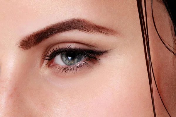 Nahaufnahme eines blauen Frauenauges mit schönen braunen Augen — Stockfoto