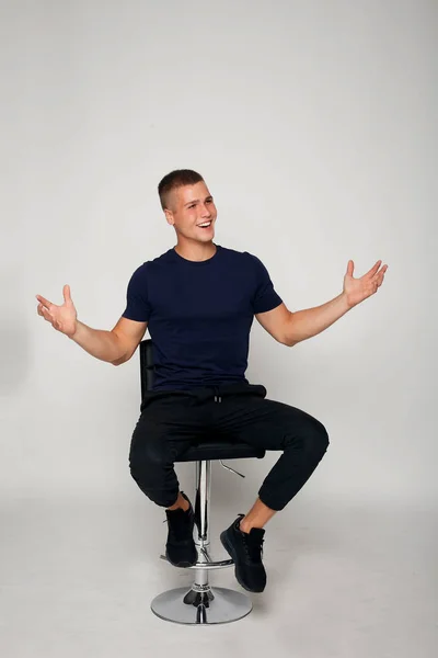 Young fashion man sitting on a chair — Stock Photo, Image