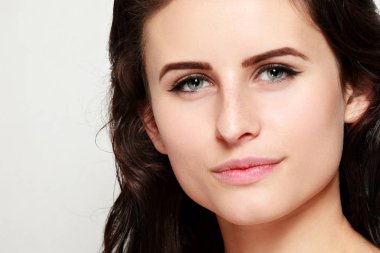 Güzel bir kadın yüzü portre genç stüdyo gri yukarı kapatın