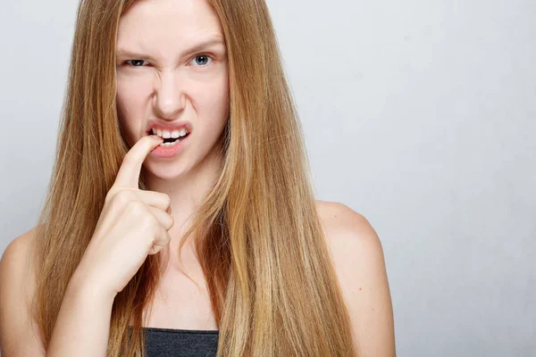Portrait of nervous pretty young woman biting her nails — Stock Photo, Image