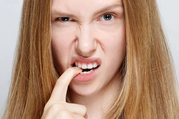 Portrait of nervous pretty young woman biting her nails — Stock Photo, Image