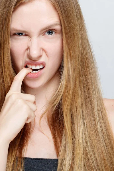 Retrato de una mujer joven y nerviosa mordiéndose las uñas — Foto de Stock