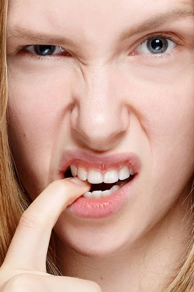 Portrait of nervous pretty young woman biting her nails — Stock Photo, Image