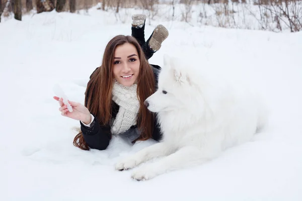 Femme propriétaire caressant embrasser blanc chien Samoyed sur la neige — Photo