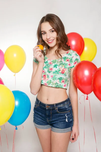 Девочка-подросток с гелиевыми шариками на сером фоне — стоковое фото