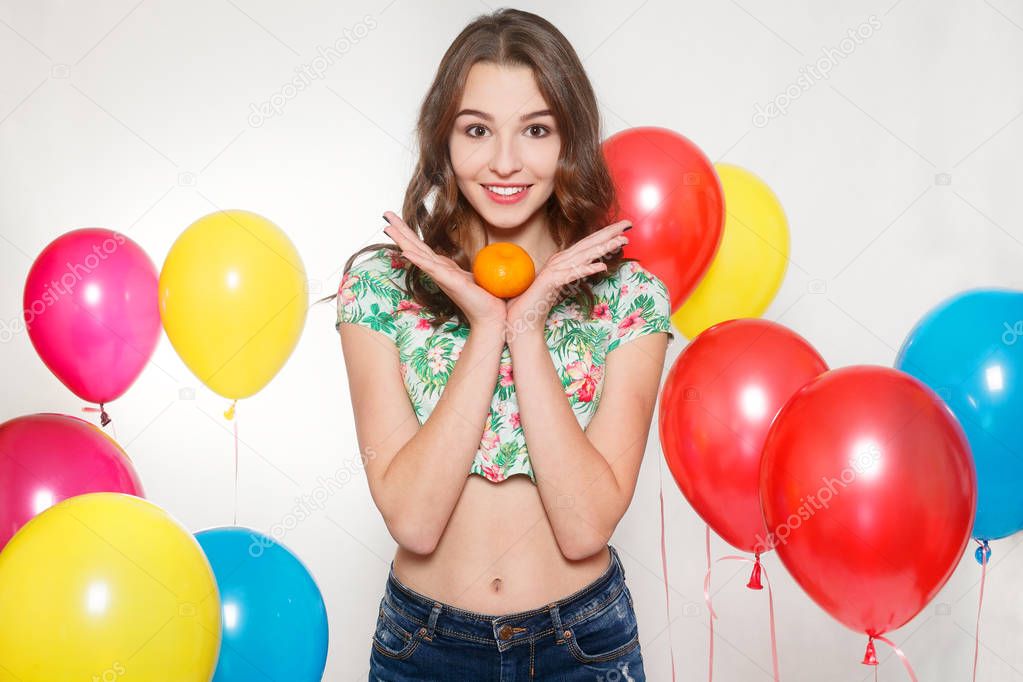 teenage girl with helium balloons over gray background