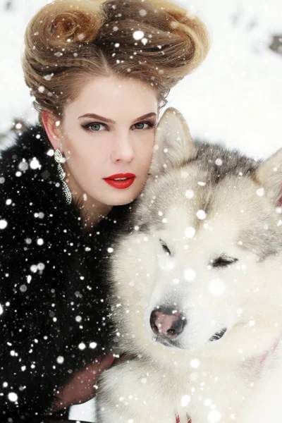 Jeune femme avec chien loup dans la neige — Photo