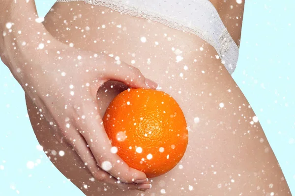 Hermosa figura femenina con una naranja sostiene cerca del culo — Foto de Stock