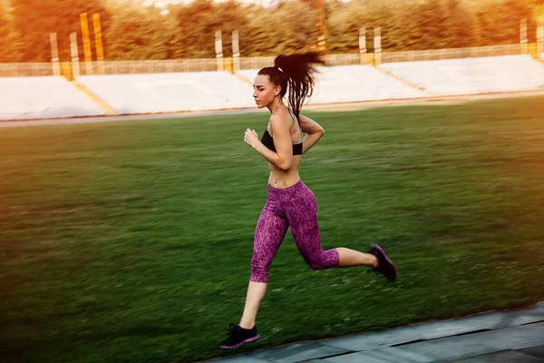 Slim athletic woman with dumbbells in the stadium — Stock Photo, Image