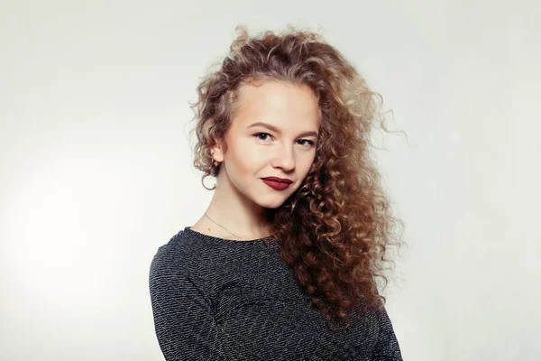 Beauty young woman with curly big and long hair.