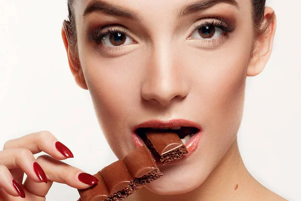 Encantadora adolescente sonriente comiendo chocolate — Foto de Stock