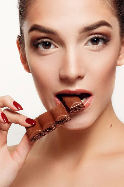 Encantadora adolescente sonriente comiendo chocolate — Foto de Stock