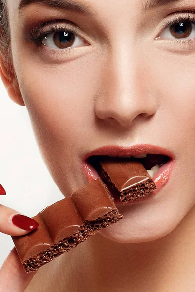 Encantadora adolescente sonriente comiendo chocolate — Foto de Stock