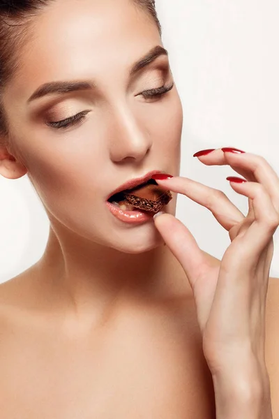 Bella ragazza adolescente sorridente mangiare cioccolato — Foto Stock