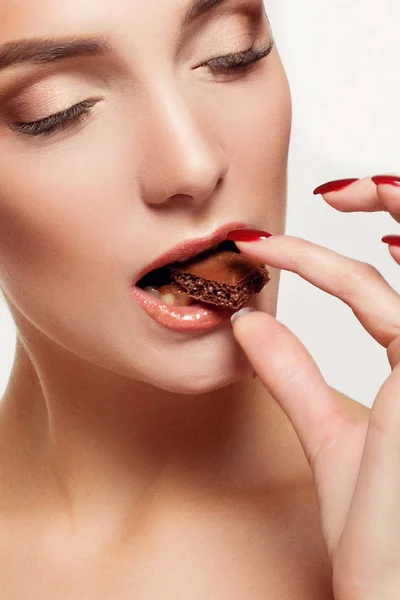 Encantadora adolescente sonriente comiendo chocolate — Foto de Stock