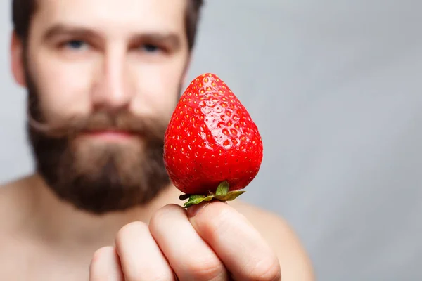 Ritratto ravvicinato giovane che tiene una fragola e sorride — Foto Stock