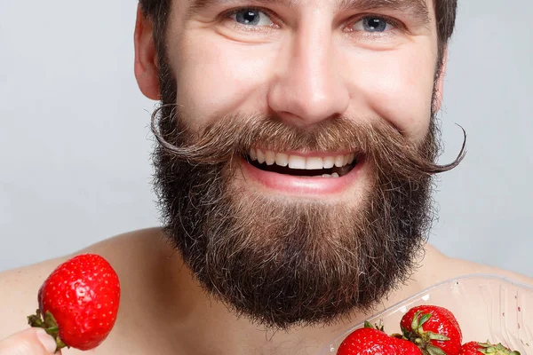 Nahaufnahme Porträt junger Mann mit Erdbeere und Lächeln — Stockfoto