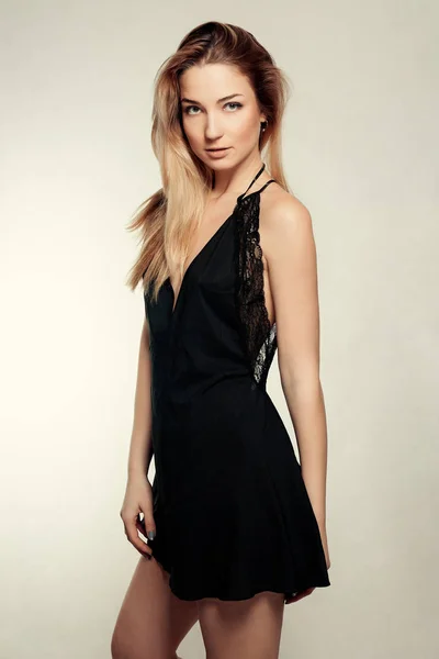 Retrato de una hermosa mujer rubia en vestido negro. Foto de moda — Foto de Stock