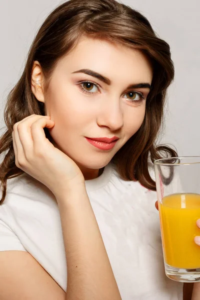 Un vaso de jugo de mujer. Modelo femenino mantenga vaso de jugo de naranja — Foto de Stock