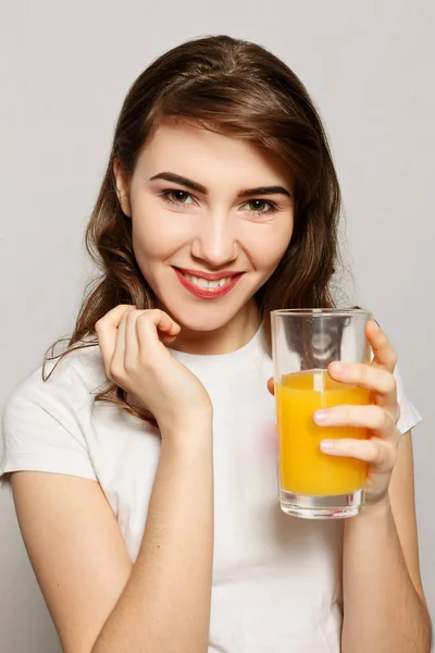 Un bicchiere di succo di donna. Modello femminile tenere vetro succo d'arancia — Foto Stock