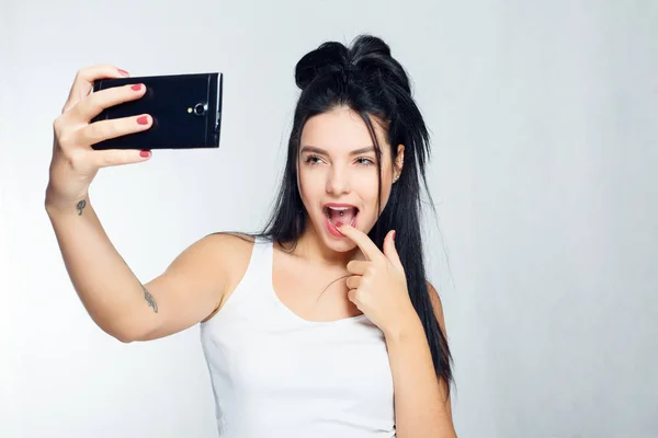 Selfie idő. Mosolygó hosszúfejű kisasszony csinál selfie szürke háttér — Stock Fotó