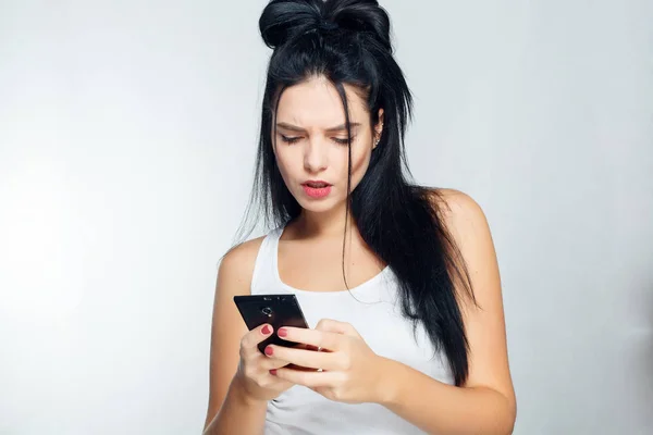 Nachdenkliche Frau in weißem Hemd am Telefon und am Telefon. isolierter grauer Hintergrund — Stockfoto