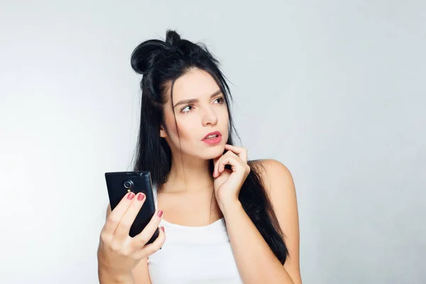 Nachdenkliche Frau in weißem Hemd am Telefon und am Telefon. isolierter grauer Hintergrund — Stockfoto