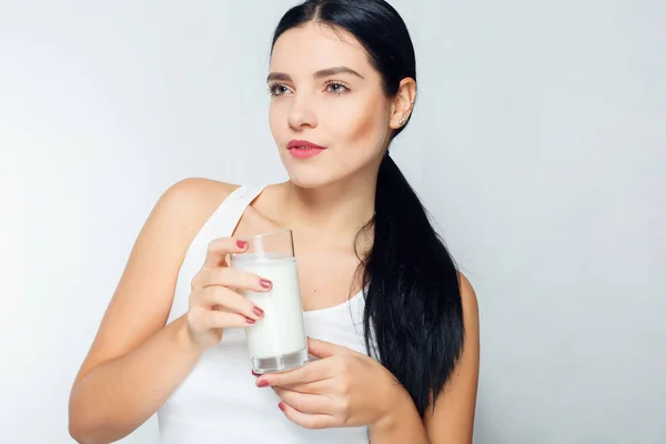 Latte Donna che beve latte, felice e sorridente bella giovane donna che si gode un latte di vetro — Foto Stock