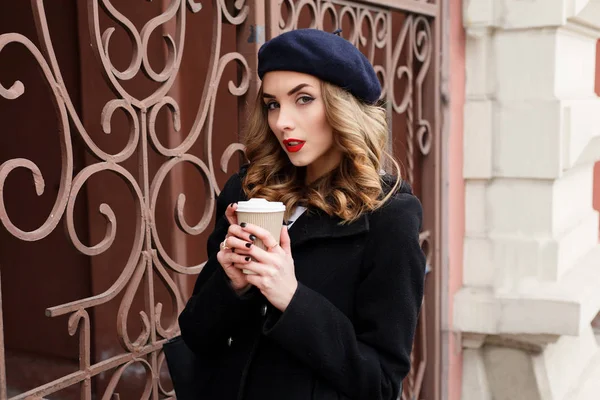 Street photo of young beautiful woman wearing stylish classic clothes.