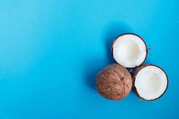 Coco maduro e meio coco sobre fundo azul — Fotografia de Stock