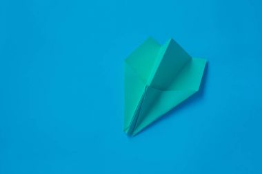 Mavi bir arka plan üzerinde sarı origami uçak.
