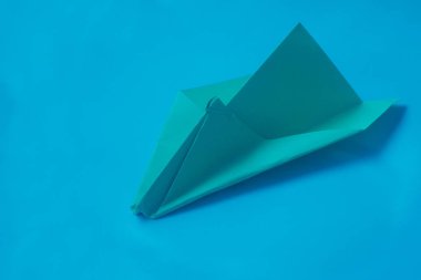 Mavi bir arka plan üzerinde sarı origami uçak.
