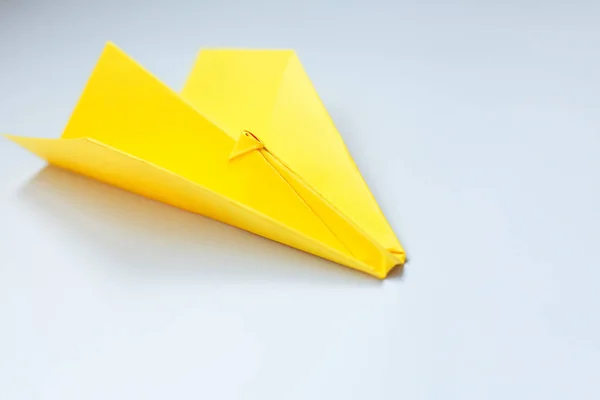 Gele origami vliegtuig op een witte achtergrond. — Stockfoto