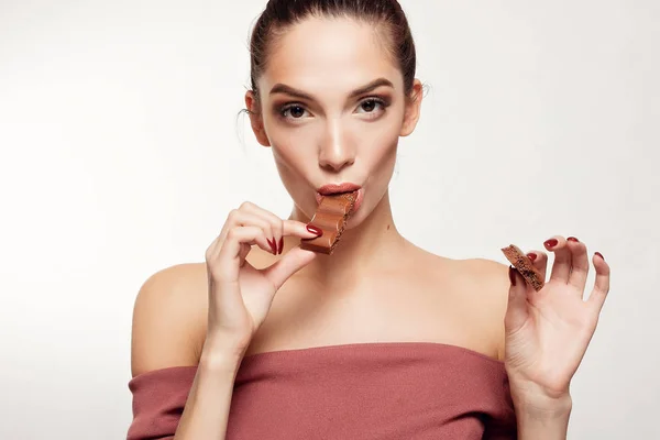 Encantadora adolescente sonriente comiendo chocolate — Foto de Stock