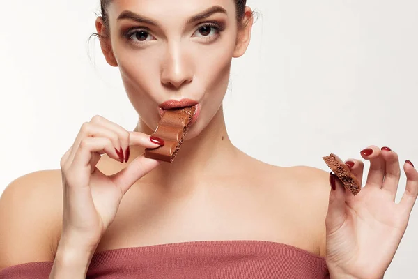 Encantadora adolescente sonriente comiendo chocolate — Foto de Stock