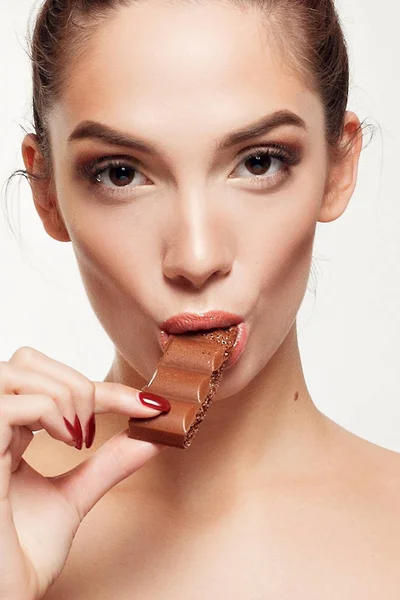 Encantadora adolescente sonriente comiendo chocolate — Foto de Stock