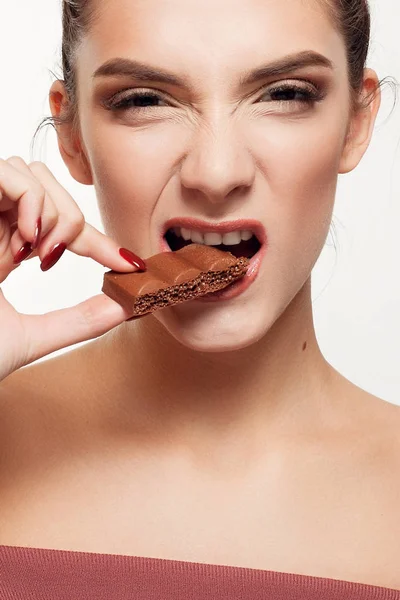 Encantadora adolescente sonriente comiendo chocolate — Foto de Stock