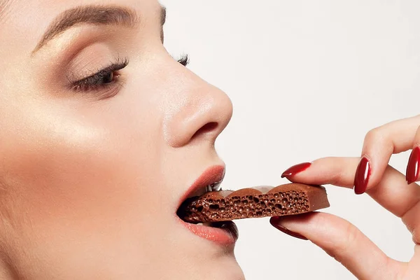 Encantadora adolescente sonriente comiendo chocolate — Foto de Stock