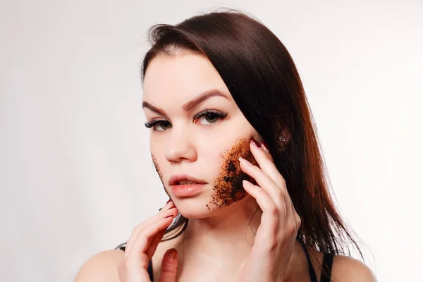 Brunette renser huden med kaffeskrubb – stockfoto