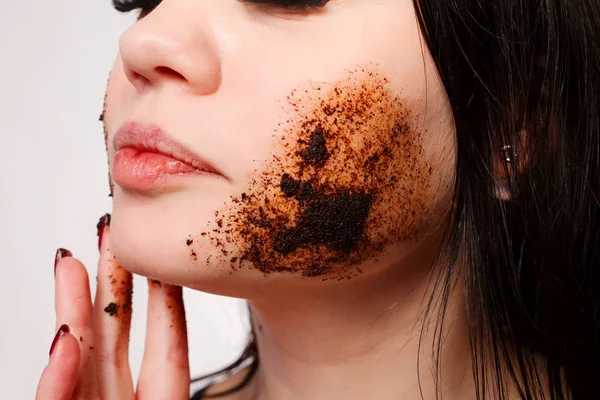 Brunette nettoie la peau avec un gommage au café — Photo
