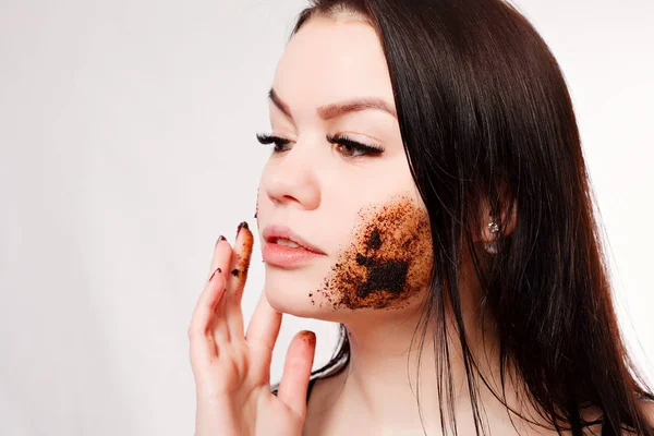 Brunette renser huden med kaffeskrubb – stockfoto