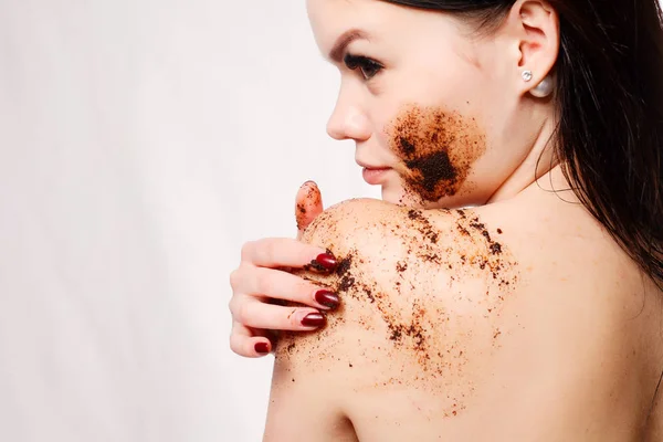 Брюнетка женщина очищает кожу тела кофе скраб — стоковое фото
