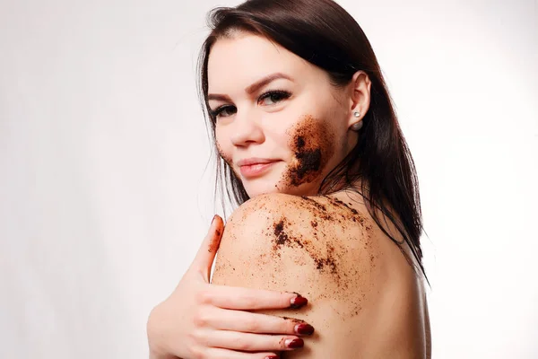 Wanita Brunette membersihkan kulit dari scrub kopi tubuh — Stok Foto