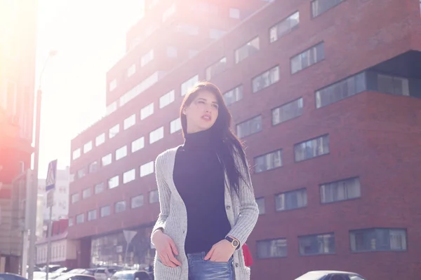 Young fashion brunette business woman against business center at sunset — Stock Photo, Image