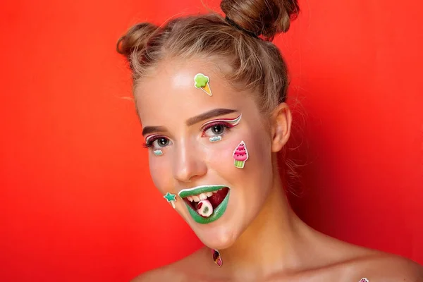 Bella giovane donna tiene in mano caramelle sorridenti ampiamente — Foto Stock