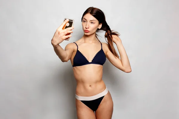 Söt flicka gör en anka står inför, och ta ett självporträtt med hennes smarta telefonen — Stockfoto