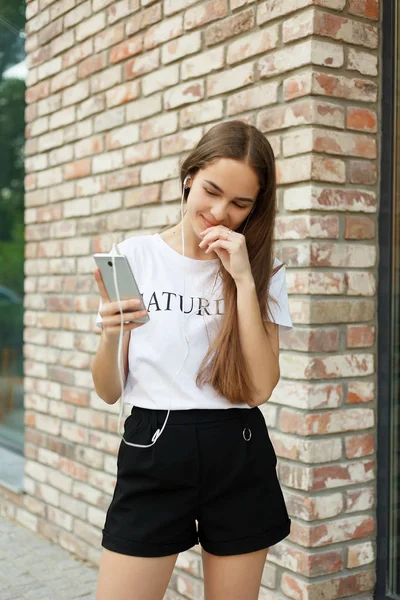 Mujer joven con auriculares colgando en su teléfono móvil — Foto de Stock